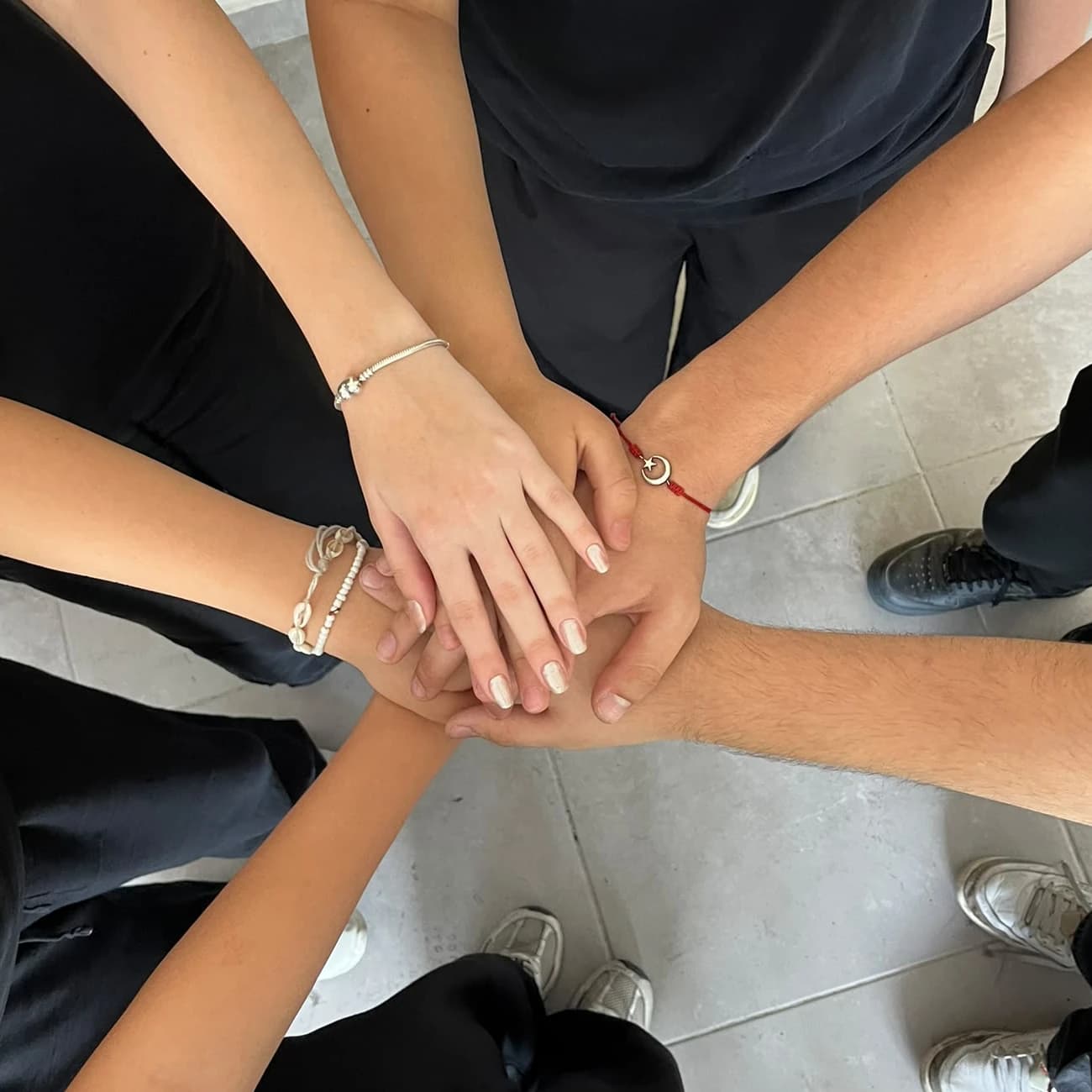 Team ALAZ members putting their hands together in unity